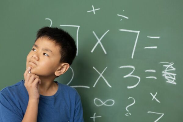 boy thinking mathematic in front of chalkboard