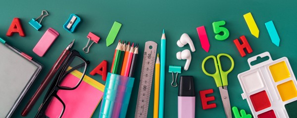 Office stationery, headphones, glasses and paints on green background